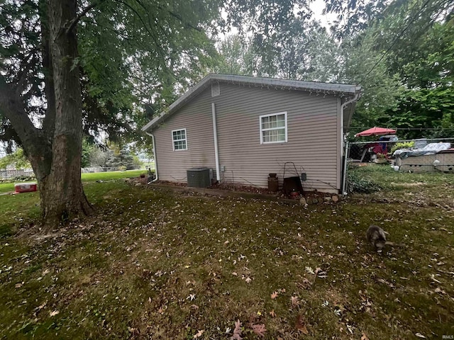 view of home's exterior featuring a lawn and central AC