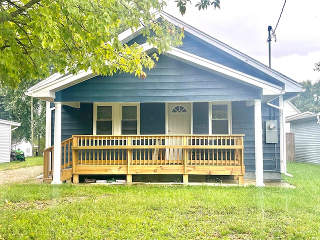 bungalow-style house with a front yard and covered porch