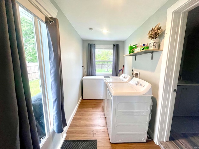 clothes washing area featuring light wood-type flooring and washer and dryer