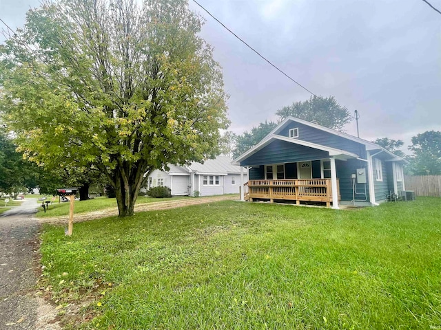 view of front of home featuring a deck, central air condition unit, and a front yard