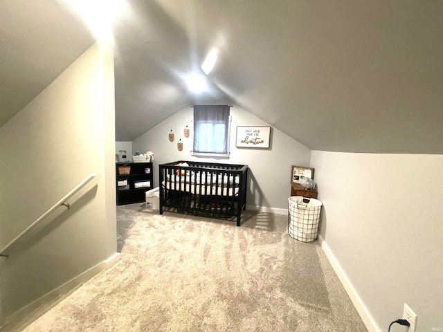 carpeted bedroom with a crib and lofted ceiling