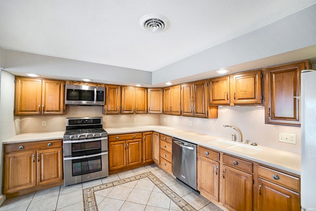 kitchen featuring light tile patterned floors, stainless steel appliances, and sink