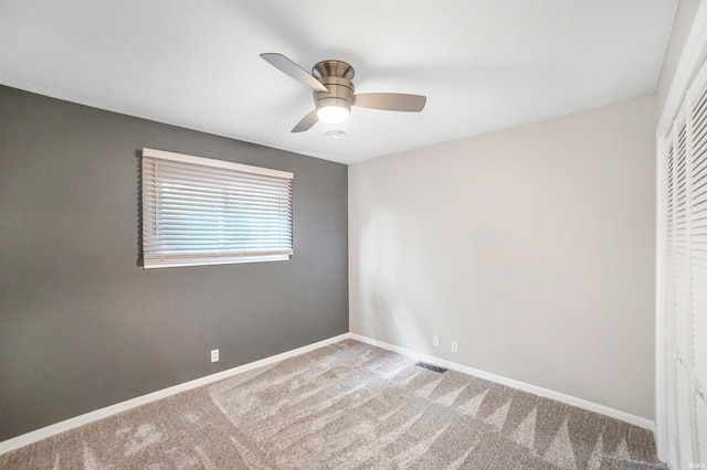 carpeted spare room with ceiling fan