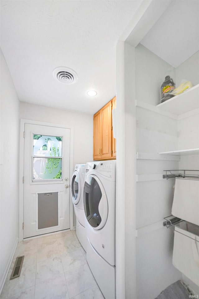 clothes washing area with independent washer and dryer and cabinets