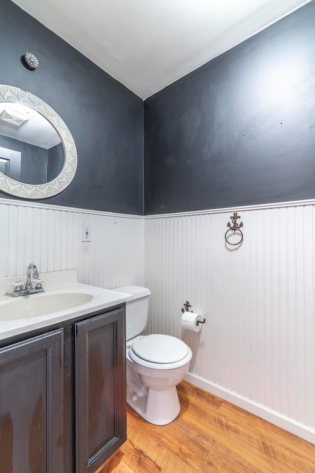 bathroom with vanity, toilet, and hardwood / wood-style flooring