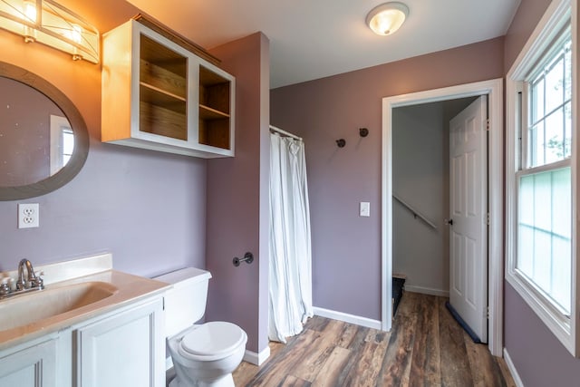 bathroom featuring curtained shower, hardwood / wood-style floors, vanity, and toilet