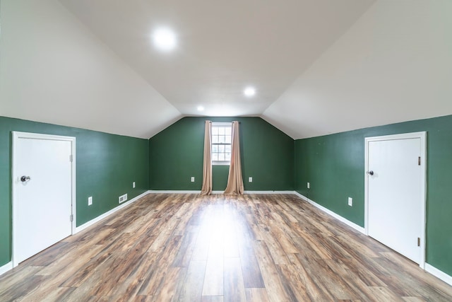 bonus room with hardwood / wood-style flooring and lofted ceiling