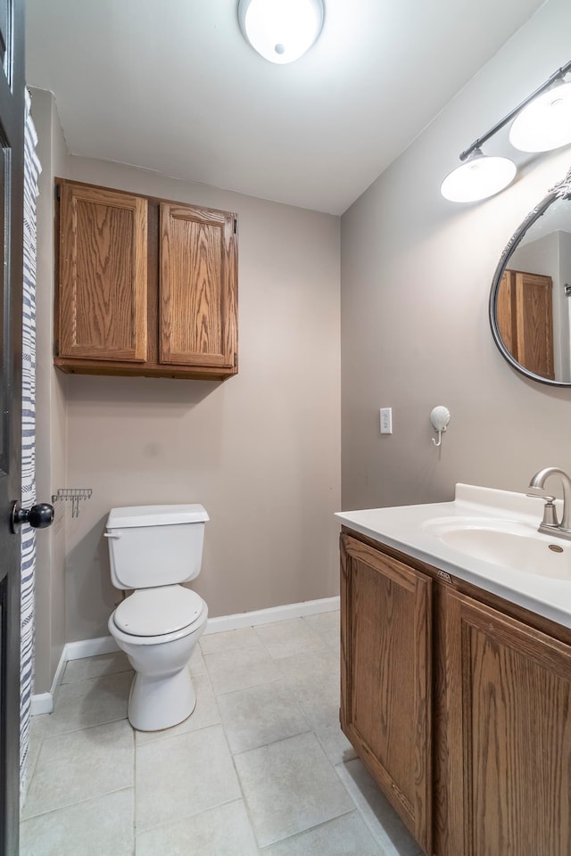 bathroom with tile patterned flooring, vanity, and toilet