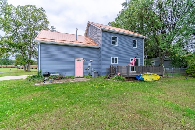 rear view of property featuring a deck, a yard, and central AC