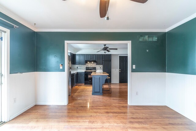 interior space with ceiling fan, ornamental molding, and light hardwood / wood-style floors