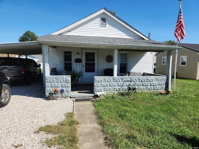 view of front facade featuring a carport, covered porch, and a front lawn