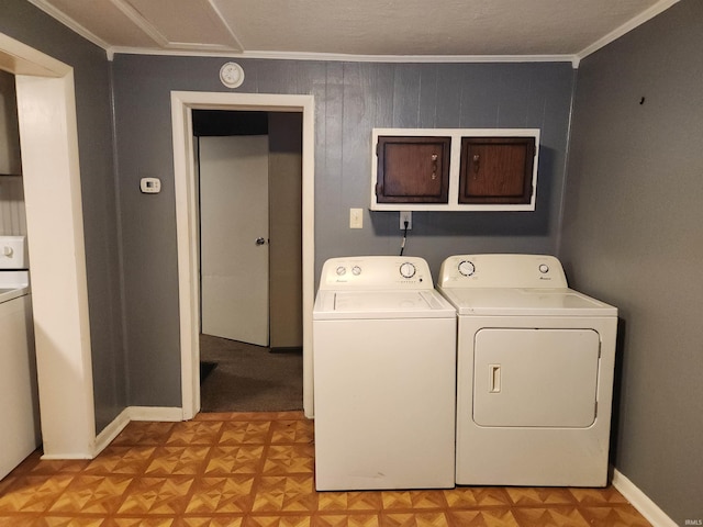 laundry room with separate washer and dryer, ornamental molding, cabinets, and light parquet floors