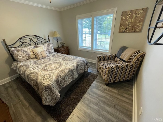 bedroom with wood finished floors, baseboards, and ornamental molding