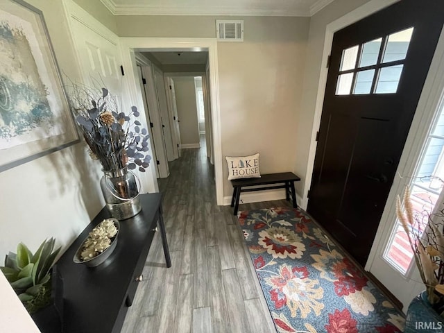 foyer entrance with wood finished floors, visible vents, crown molding, and a wealth of natural light