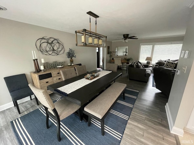 dining space with wood finished floors, a ceiling fan, and baseboards