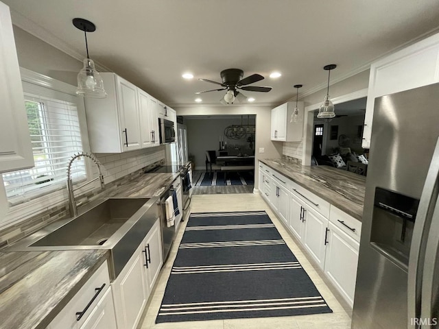 kitchen with stainless steel fridge, white cabinetry, decorative backsplash, and a sink