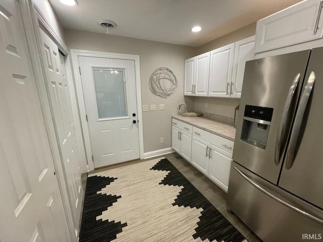 kitchen with white cabinets, visible vents, recessed lighting, stainless steel fridge with ice dispenser, and light countertops