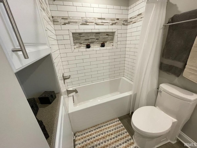 bathroom featuring wood finished floors, shower / bathtub combination with curtain, and toilet