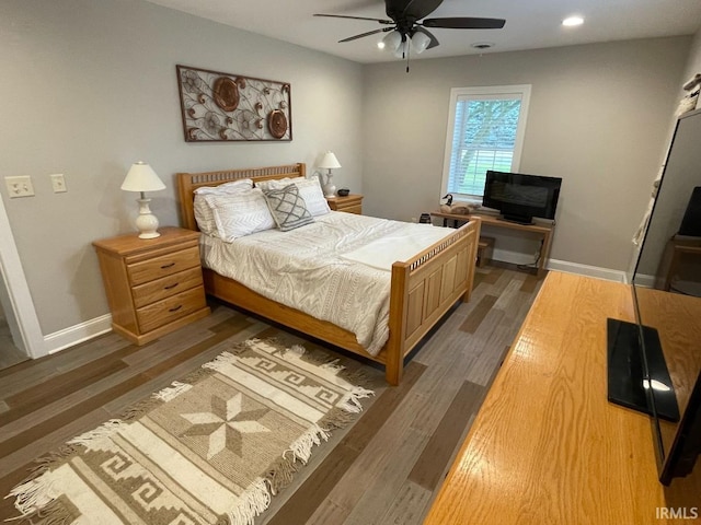 bedroom featuring baseboards, wood finished floors, and recessed lighting