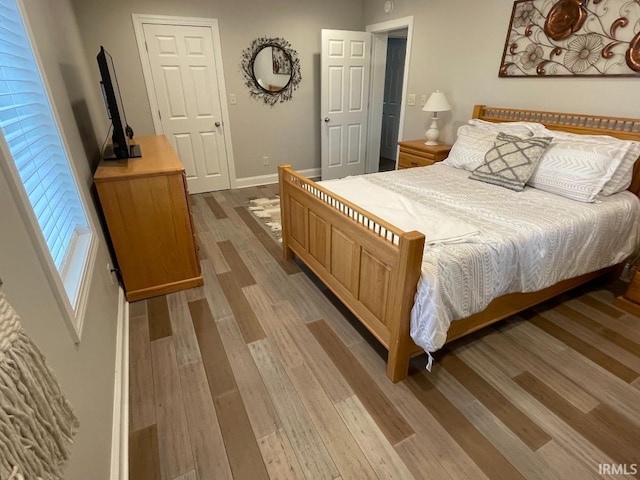 bedroom with light wood-style floors and baseboards