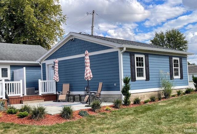 rear view of house with a yard, central AC, and a patio