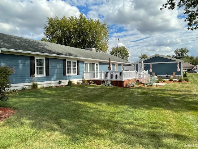 rear view of house with a wooden deck, a lawn, and a chimney