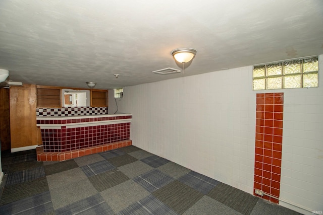 interior space with dark colored carpet and bar