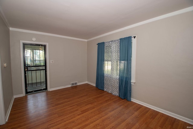 unfurnished room featuring wood-type flooring and ornamental molding