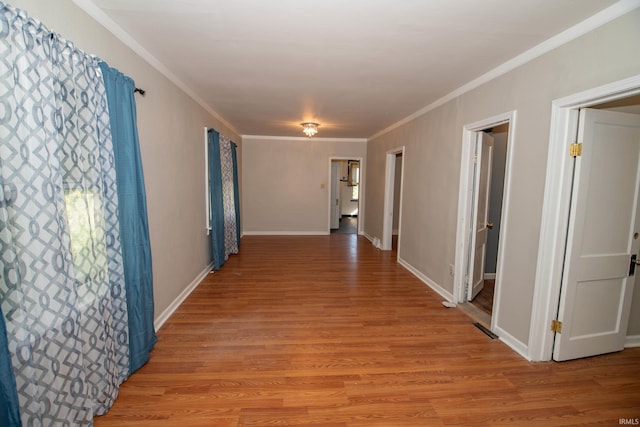 hall with crown molding and light hardwood / wood-style floors