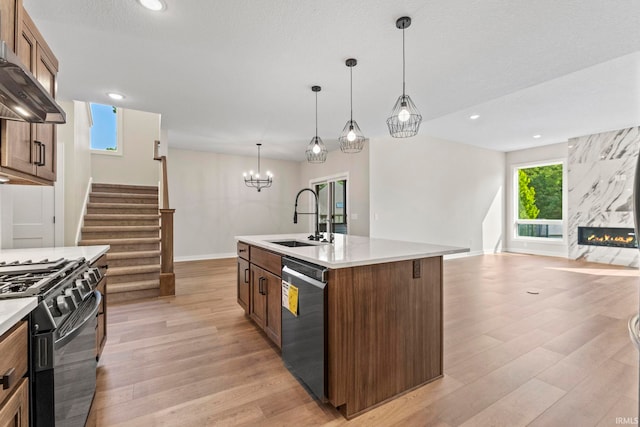 kitchen featuring a kitchen island with sink, sink, pendant lighting, and appliances with stainless steel finishes