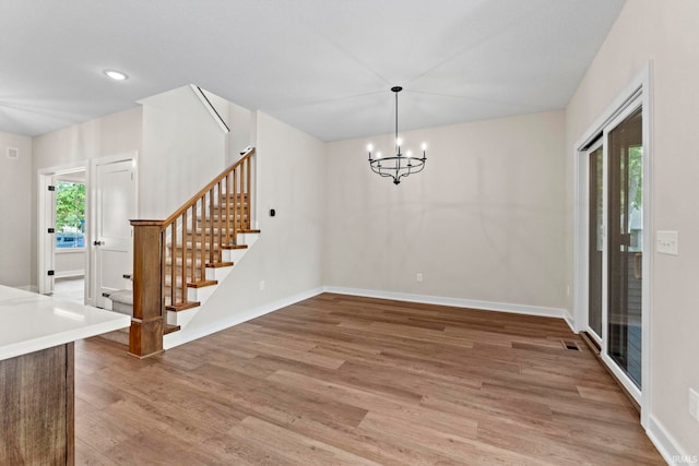 unfurnished dining area featuring hardwood / wood-style flooring, a notable chandelier, and a wealth of natural light