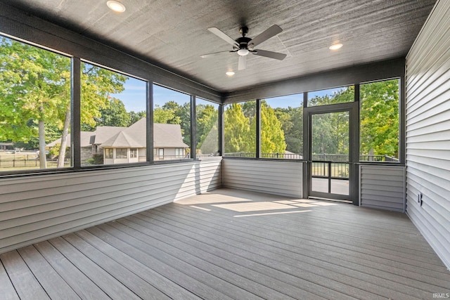 unfurnished sunroom featuring ceiling fan and a healthy amount of sunlight