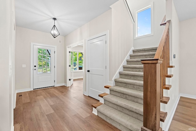 entryway featuring light hardwood / wood-style floors and an inviting chandelier