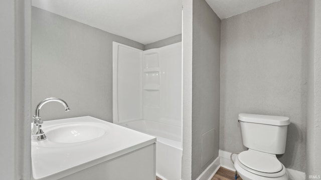 full bathroom featuring wood-type flooring, bathing tub / shower combination, vanity, and toilet