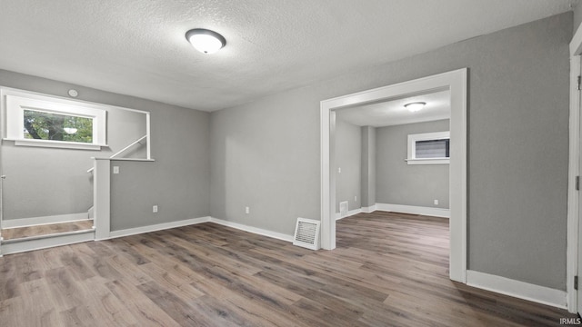 unfurnished room featuring a textured ceiling and dark wood-type flooring