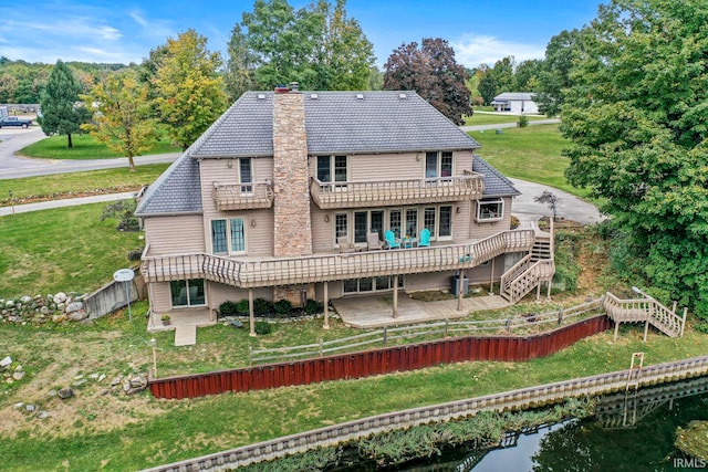 rear view of house with a deck and a yard