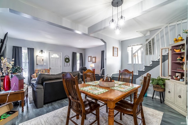 dining room featuring beam ceiling, plenty of natural light, and dark hardwood / wood-style flooring