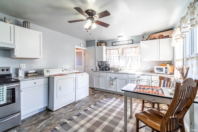 kitchen with washing machine and dryer, white cabinets, stainless steel range with electric stovetop, exhaust hood, and ceiling fan