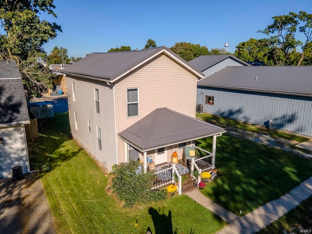 back of property featuring a lawn, cooling unit, and a porch