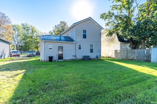 rear view of property with a lawn and central AC