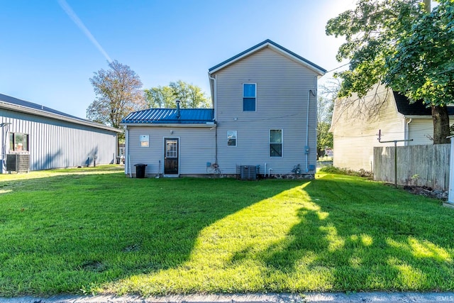 rear view of property with a lawn and central AC