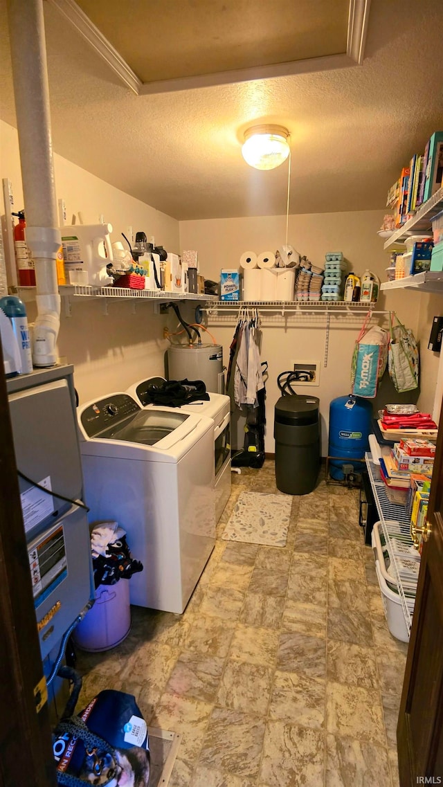 laundry room with water heater, a textured ceiling, and independent washer and dryer