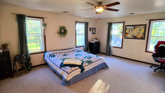 bedroom featuring multiple windows, light carpet, and ceiling fan