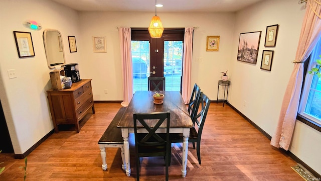 dining space with hardwood / wood-style floors and french doors