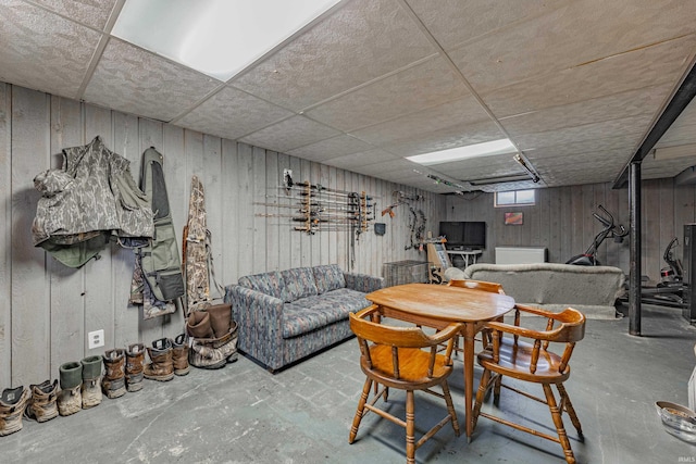 living room featuring concrete flooring and a paneled ceiling