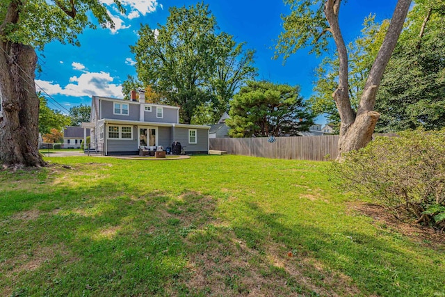 rear view of property featuring a lawn