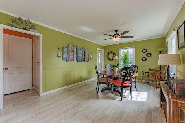 dining room with light hardwood / wood-style floors, ceiling fan, and ornamental molding