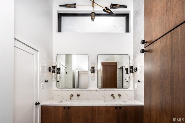 bathroom with double vanity, a high ceiling, and a sink