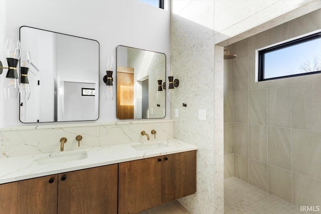 bathroom featuring double vanity, a walk in shower, and a sink