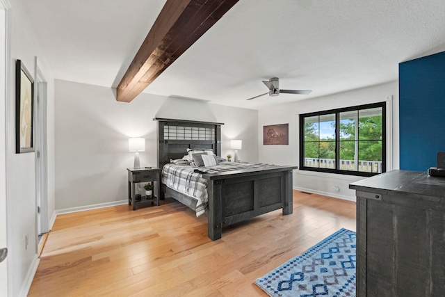 bedroom featuring light hardwood / wood-style floors, ceiling fan, and beamed ceiling